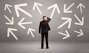 Man confused looking at arrows pointing in several different directions.